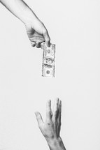 hand giving money to a reaching hand