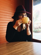woman holding a cappuccino cup and drinking 