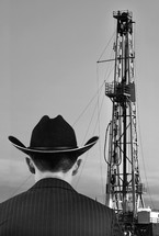 oilman standing in front of an oil rig 