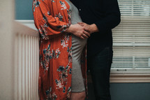 an expecting couple standing in a baby nursery 