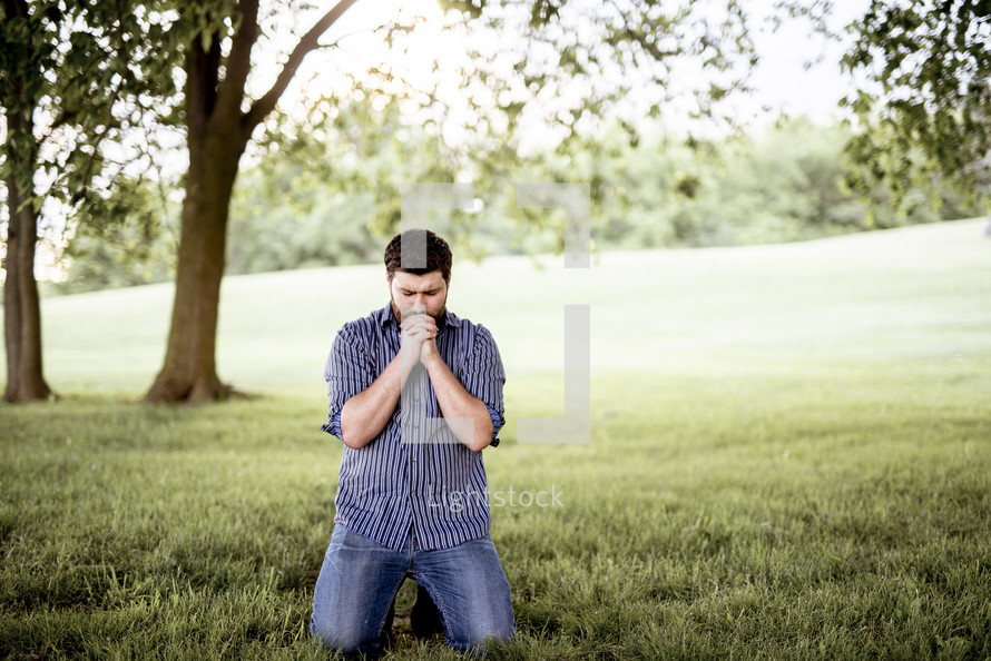 a man praying outdoors 