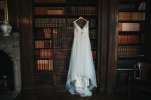 wedding dress hanging in a library 