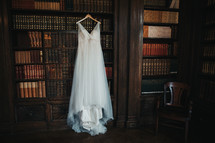 wedding gown hanging in a library 