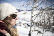 woman in wool cap standing outdoors in snow 