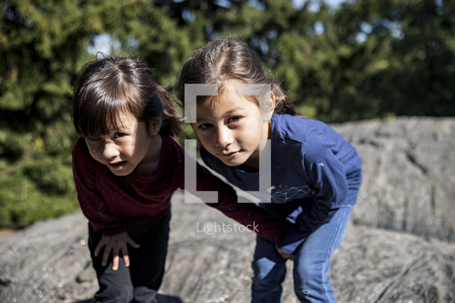 Little girls playing on a rock