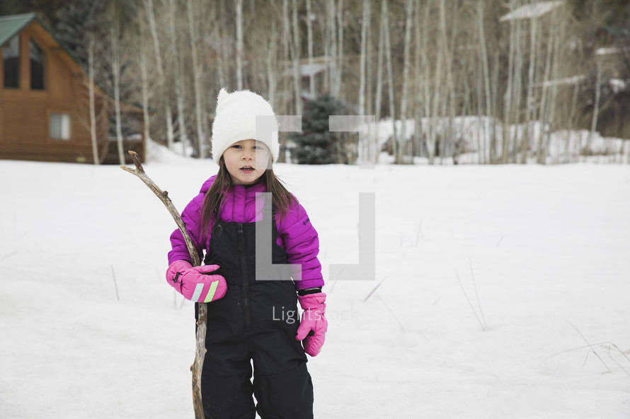 a child in a snowsuit playing outdoors 