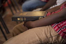 child holding a Bible in his lap 