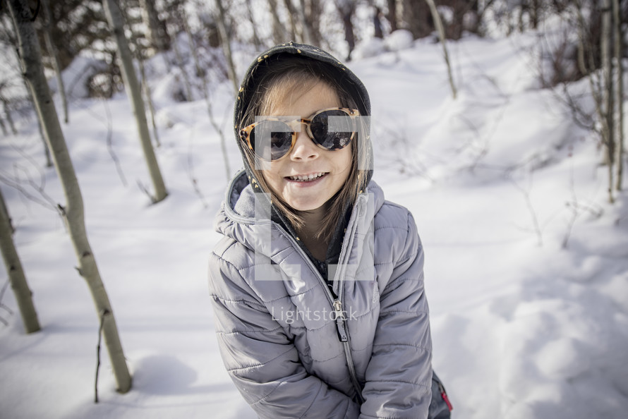 smiling girl standing in snow 