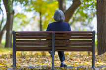 a woman sitting alone on a bench 