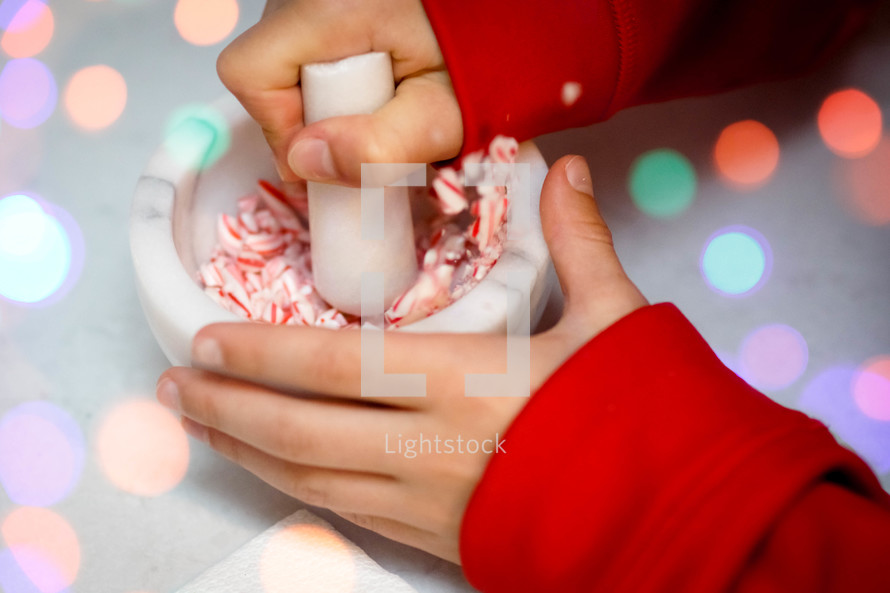 a child crushing candy canes 