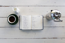 open Bible on a wood floor and coffee cup 