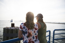 women looking over a railing on a pier 