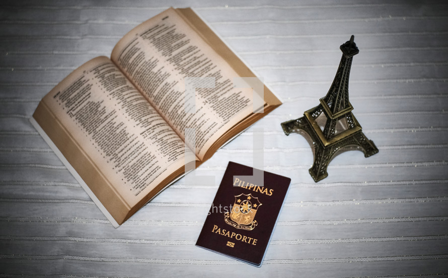 opened Bible, passport, and eiffel tower 