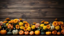 Autumn background with pumpkins, flowers and leaves on wooden board