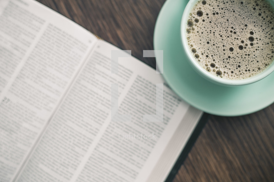 coffee cup and page of a Bible 