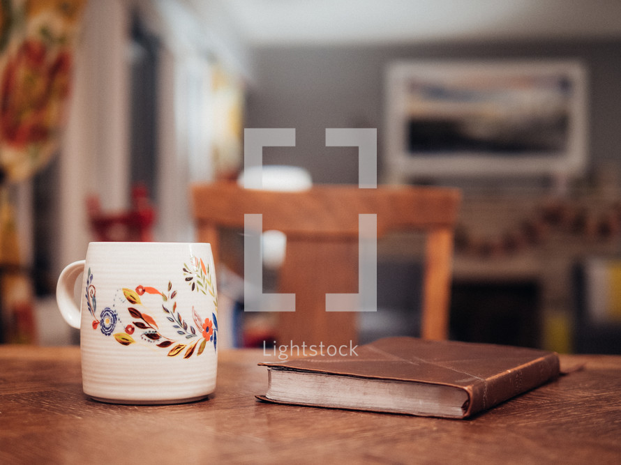 coffee mug and Bible on a wood table 