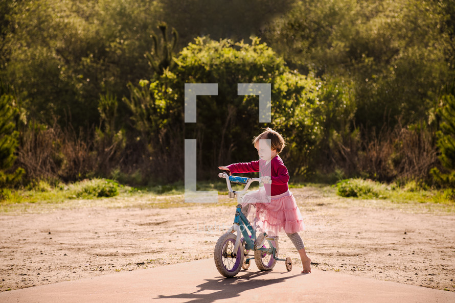 a toddler girl with a bicycle 