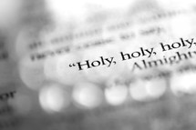 A macro shot of the words "Holy, holy, holy", in black-and-white. 