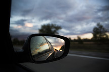 rain on car mirror at sunset 