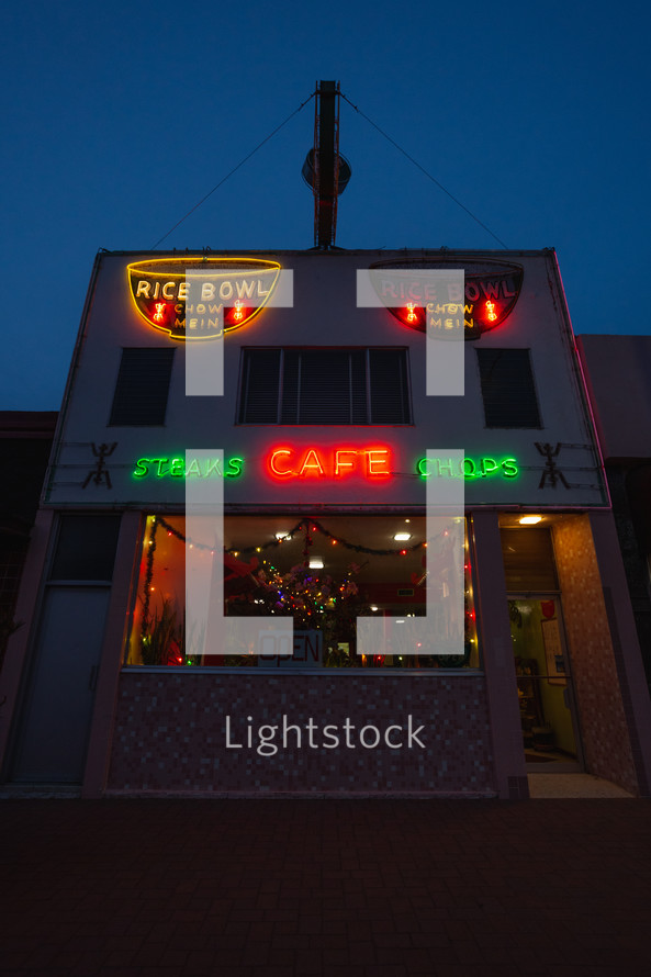 Small town restaurant with neon signs and Christmas lights at night