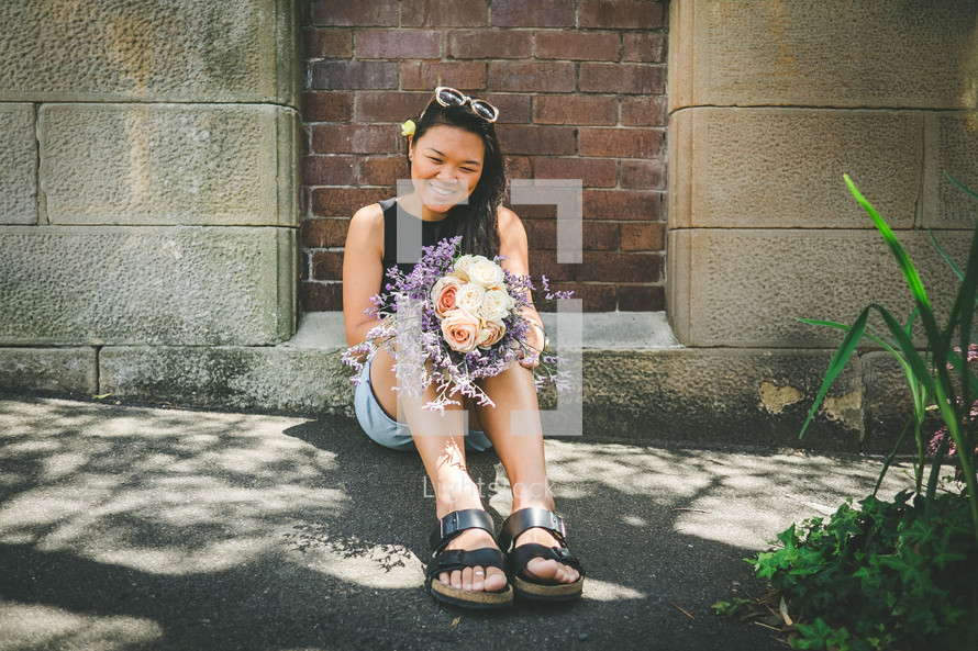 woman sitting holding a bouquet of flowers 