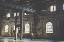 woman standing in an empty warehouse 