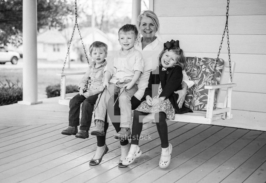 grandmother on a porch swing with her grandchildren 