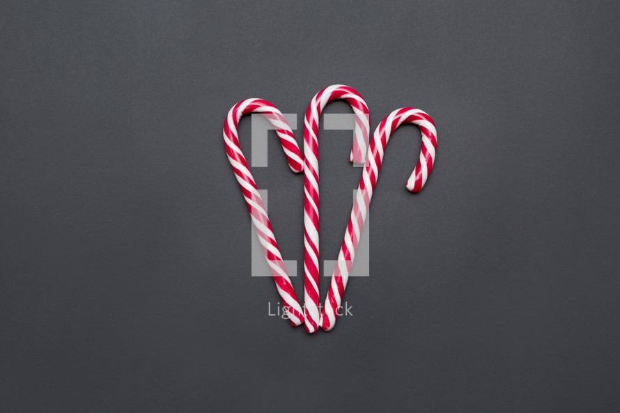 three candy canes on a gray background 