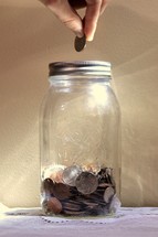 putting coins in a mason jar 