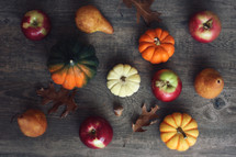 pumpkins and fall leaves on a wood background 