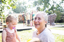 Smiling woman with toddler at playground
