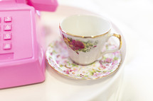 pink rotary telephone and tea cup 