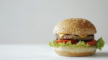 Close-up image of a classic cheeseburger with a juicy beef patty, melted cheese, fresh tomato slices, crisp lettuce, and a sesame seed bun.