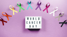 world cancer awareness day ribbons in flat layer background