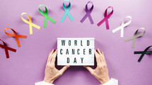 world cancer awareness day ribbons in flat layer background