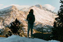 Female Hiker looking around at beautiful snowy mountains