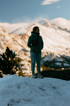 Female Hiker looking around at beautiful snowy mountains