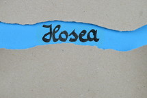 Hosea - torn open kraft paper over blue paper with the name of the prophetic book Hosea