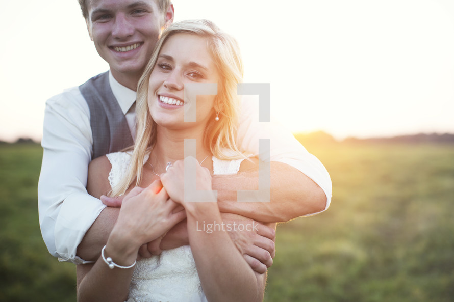 bride and groom hugging outdoors 