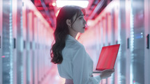 Woman in data center with laptop, tech leadership.