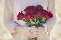 woman holding a bouquet of red roses 