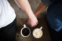 a couple holding hands and hot cocoa 