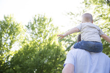 a toddler boy on father's shoulders 