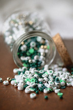 Jar of green, white, and gold beads