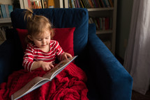 a little girl reading a children's book 