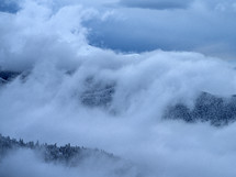 clouds over a winter mountain forest 
