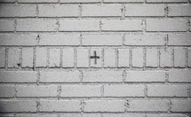 cross in ashes on a white brick wall 