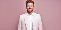 Cheerful young businessman with ginger hair in a pastel pink blazer.