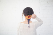 a woman with a braid and flowers in her hair 