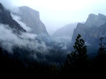 The Canyons, cliffs and mountainous landscape of Yosemite National Forest surrounded by clouds and early morning fog on a cool February winter morning in Central California. 